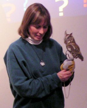 teacher holding a live own in front of students